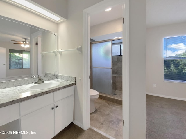 bathroom featuring ceiling fan, vanity, an enclosed shower, and toilet