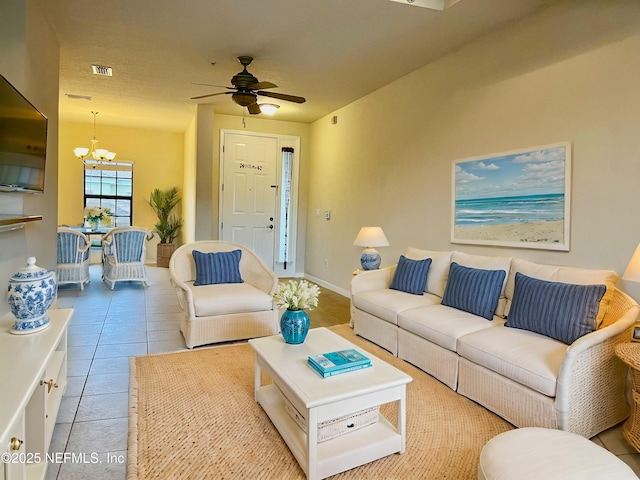 living room featuring ceiling fan with notable chandelier and light tile patterned flooring