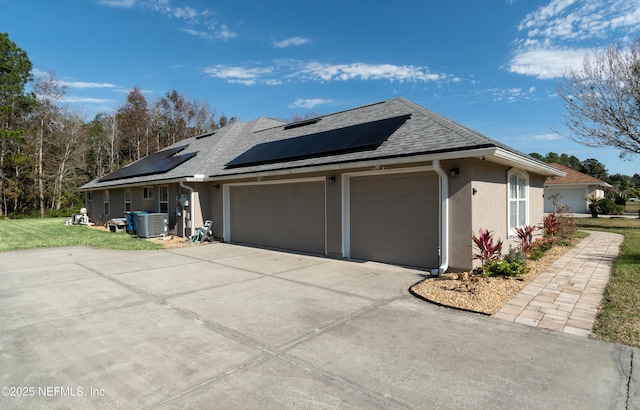 view of home's exterior featuring a garage, central AC unit, and solar panels