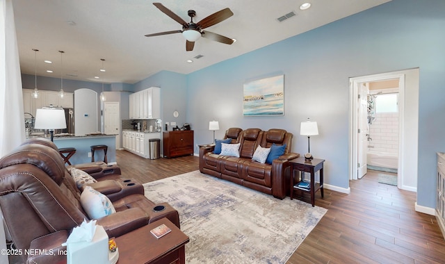 living room featuring ceiling fan and dark wood-type flooring