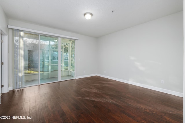 spare room featuring hardwood / wood-style floors and a textured ceiling