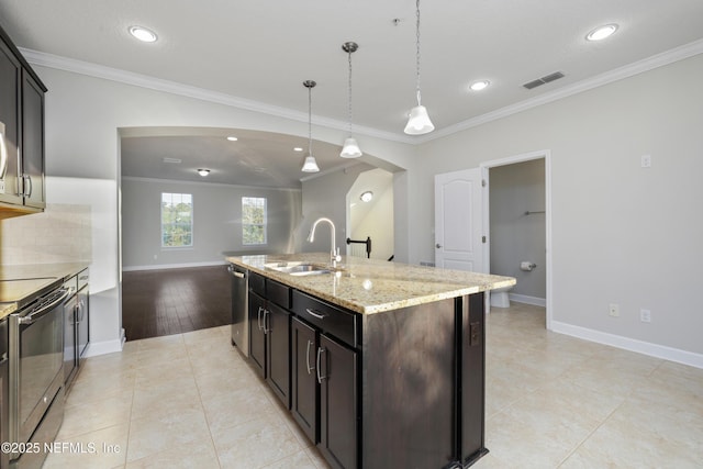 kitchen with ornamental molding, stainless steel appliances, and a center island with sink