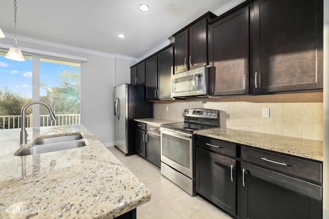 kitchen featuring pendant lighting, backsplash, sink, light stone counters, and stainless steel appliances