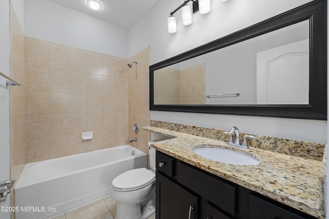 full bathroom featuring tiled shower / bath combo, tile patterned flooring, a textured ceiling, toilet, and vanity