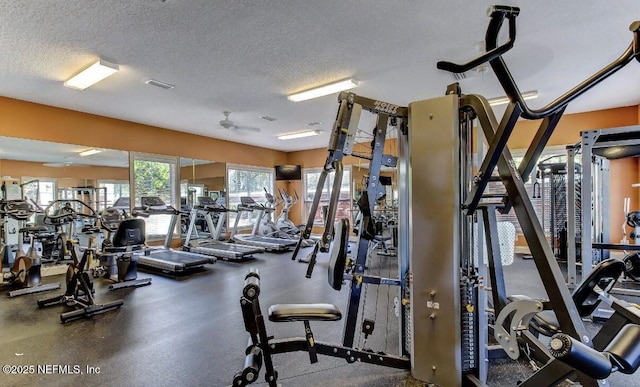 gym with ceiling fan and a textured ceiling