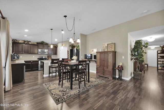 dining space featuring dark hardwood / wood-style flooring and an inviting chandelier