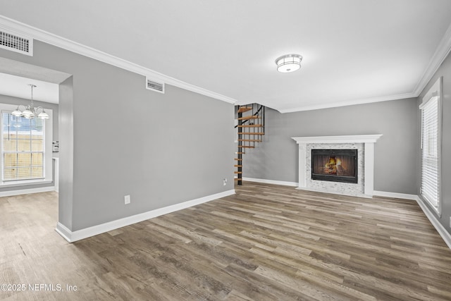 unfurnished living room featuring hardwood / wood-style flooring, plenty of natural light, and ornamental molding