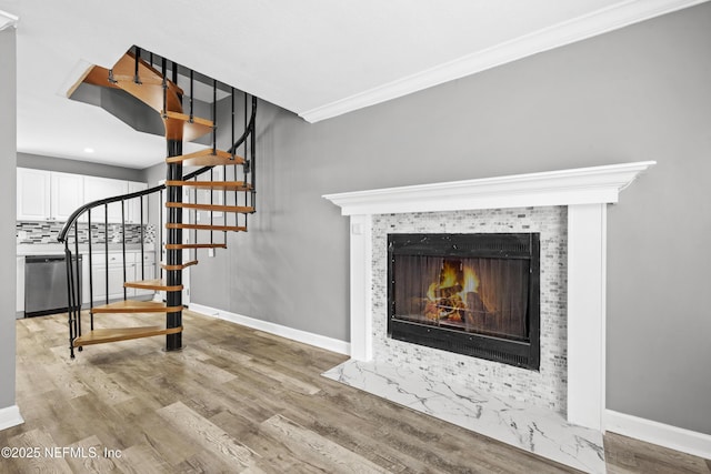 interior space with a fireplace, hardwood / wood-style flooring, and crown molding