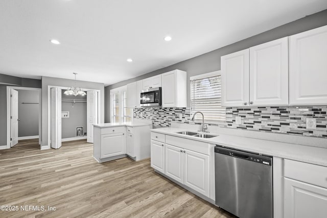 kitchen with sink, a chandelier, decorative light fixtures, white cabinets, and appliances with stainless steel finishes