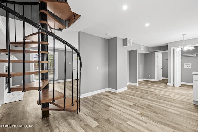 stairs with hardwood / wood-style flooring and a notable chandelier