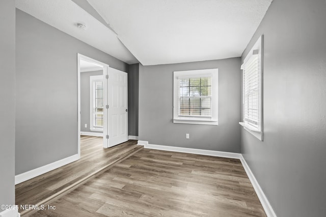 empty room with hardwood / wood-style floors and a textured ceiling