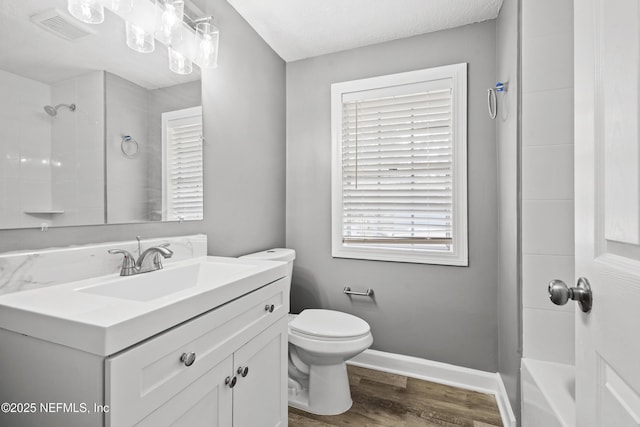 full bathroom with shower / bath combination, vanity, a textured ceiling, hardwood / wood-style floors, and toilet