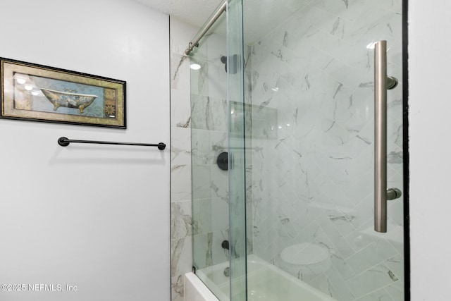 bathroom with bath / shower combo with glass door and a textured ceiling