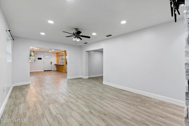 unfurnished living room with ceiling fan and light wood-type flooring