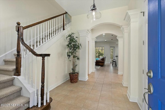 entrance foyer featuring light tile patterned floors and decorative columns