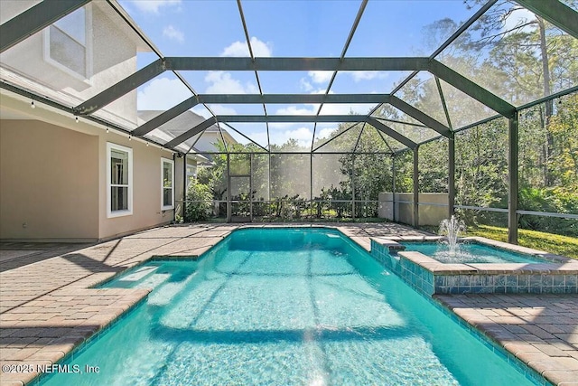 view of pool with a lanai, pool water feature, and an in ground hot tub