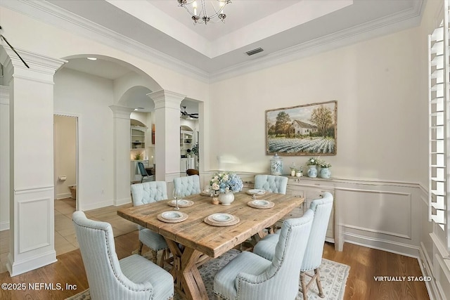 dining room featuring ornate columns, crown molding, hardwood / wood-style flooring, and ceiling fan