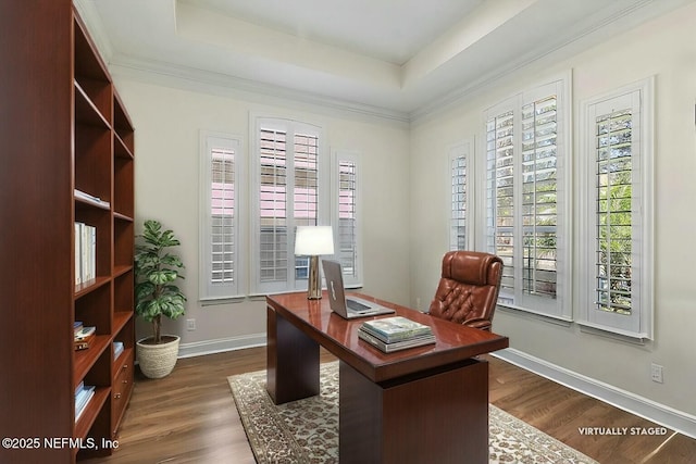 office with dark hardwood / wood-style floors, ornamental molding, and a raised ceiling