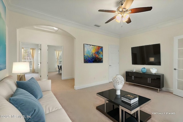 living room featuring ceiling fan, ornamental molding, and light carpet