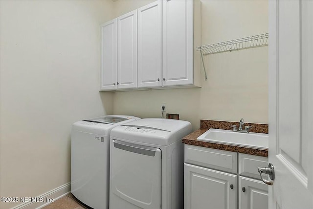 laundry area with cabinets, washing machine and dryer, sink, and light tile patterned floors