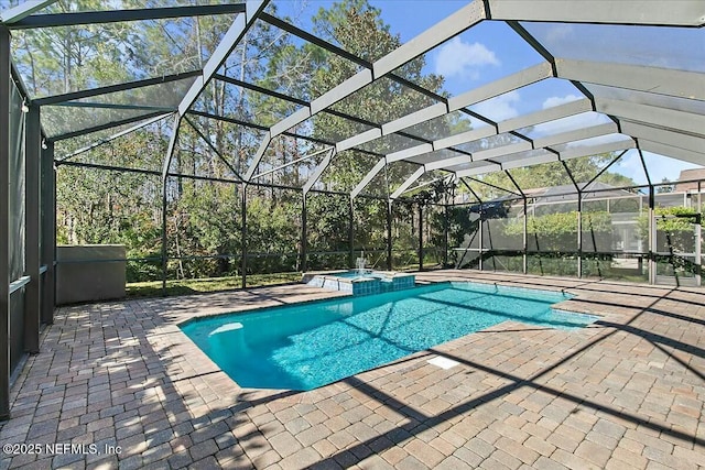 view of swimming pool with an in ground hot tub, a patio, and glass enclosure