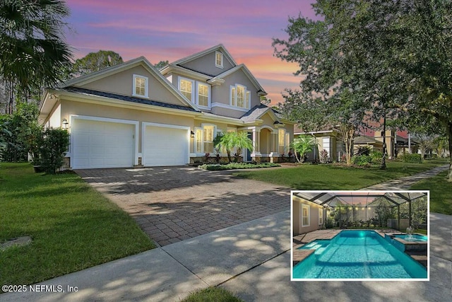 view of front of property with a garage and a lawn