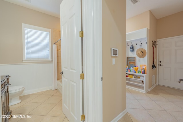 bathroom featuring bathing tub / shower combination, tile patterned flooring, and toilet