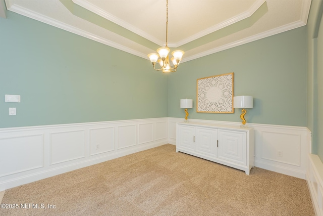 unfurnished room featuring a chandelier, light carpet, a raised ceiling, and crown molding