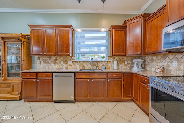 kitchen featuring appliances with stainless steel finishes, tasteful backsplash, hanging light fixtures, and sink