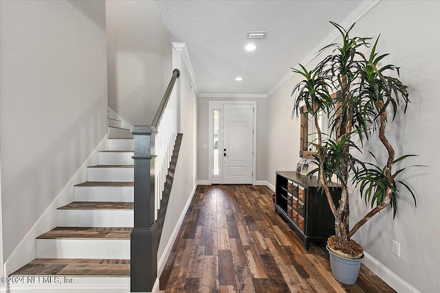 foyer with a textured ceiling, crown molding, and dark wood-type flooring