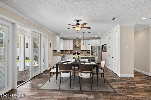 dining room featuring ceiling fan, dark wood-type flooring, a textured ceiling, and ornamental molding