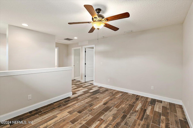 unfurnished room featuring ceiling fan, dark wood-type flooring, and a textured ceiling