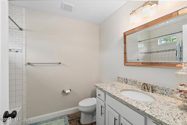 bathroom with vanity, a textured ceiling, and toilet