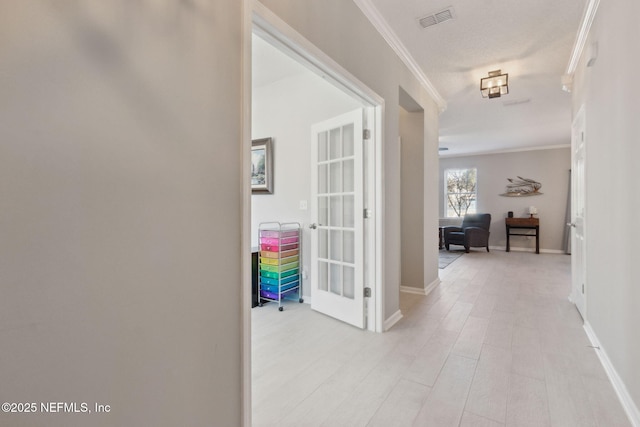 hall featuring a textured ceiling and crown molding