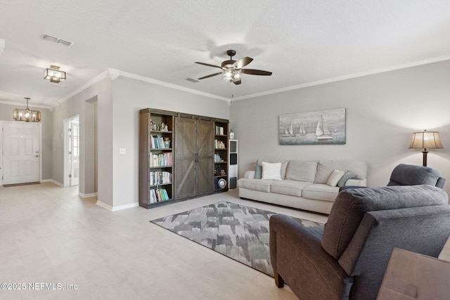 living room featuring a textured ceiling, a barn door, crown molding, and ceiling fan with notable chandelier