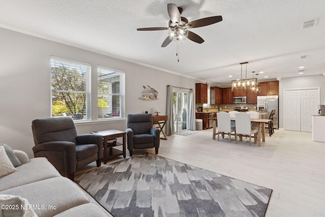 living room with a textured ceiling, light wood-type flooring, ceiling fan, and crown molding