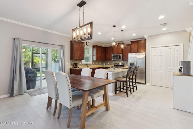 dining room featuring a chandelier, crown molding, and sink