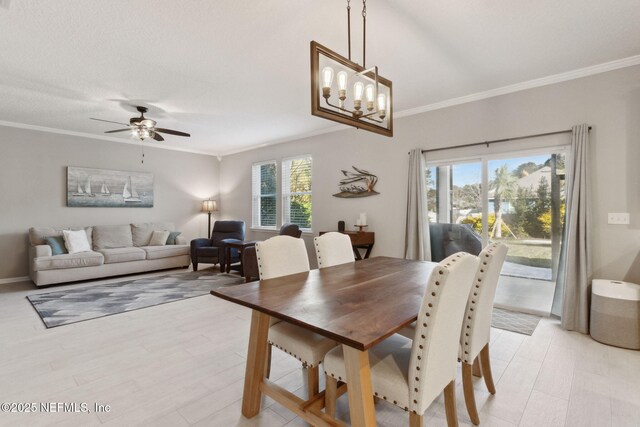 dining space featuring a textured ceiling, crown molding, and ceiling fan with notable chandelier