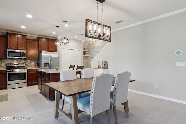 dining area with a notable chandelier and crown molding