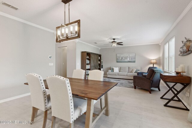 dining room featuring crown molding and ceiling fan with notable chandelier