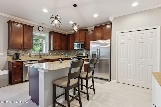 kitchen featuring stainless steel appliances, tasteful backsplash, light stone counters, decorative light fixtures, and a kitchen island