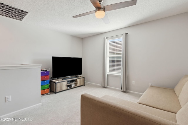 living room featuring carpet, ceiling fan, and a textured ceiling