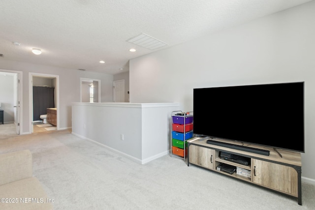 living room featuring light colored carpet and a textured ceiling