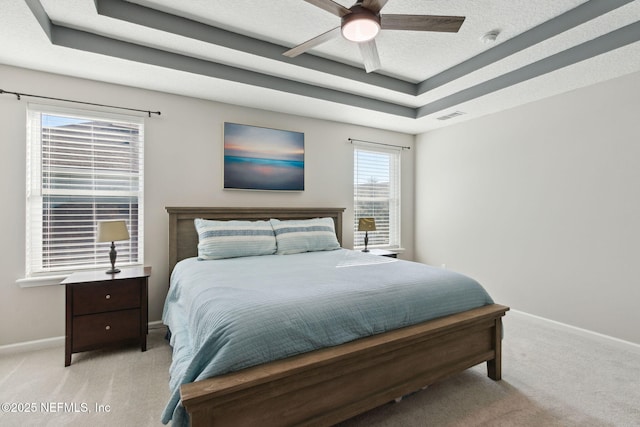 bedroom with a raised ceiling, ceiling fan, and light colored carpet