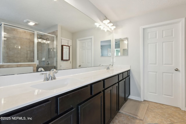 bathroom featuring a textured ceiling, vanity, tile patterned floors, and a shower with door