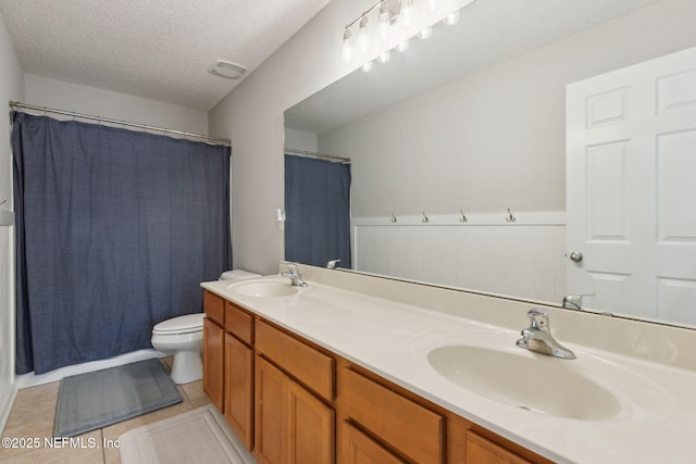 bathroom with vanity, a textured ceiling, tile patterned flooring, toilet, and curtained shower