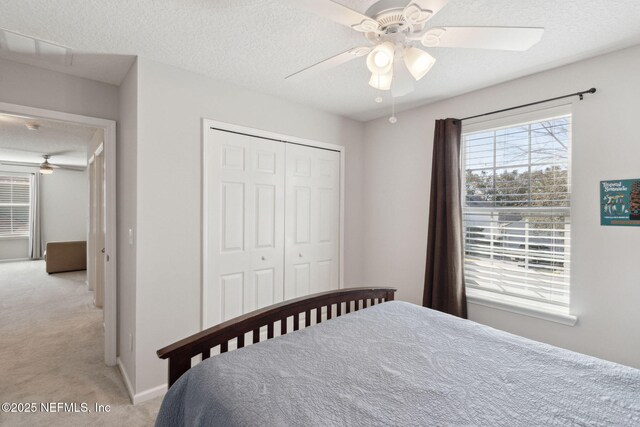 carpeted bedroom featuring ceiling fan, a textured ceiling, and a closet