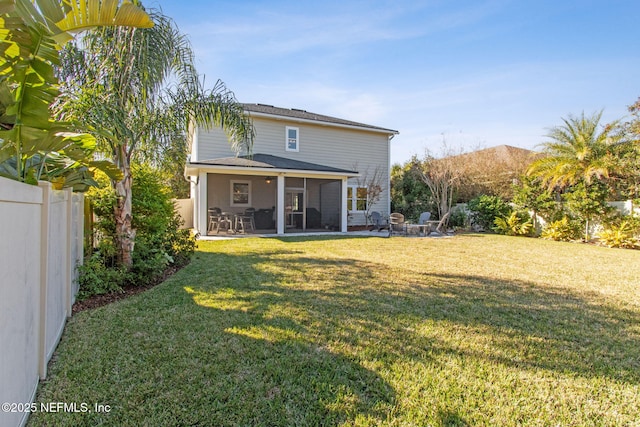 back of house with a sunroom, a patio, and a lawn