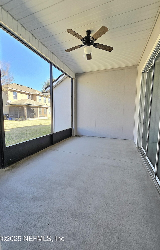 unfurnished sunroom featuring ceiling fan