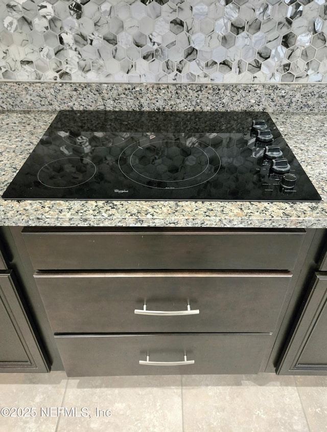 interior details featuring black electric cooktop and light stone counters